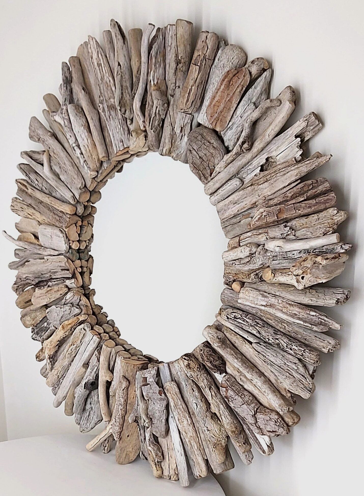 This driftwood mirror titled Salt Frosted uses white and light grey woods