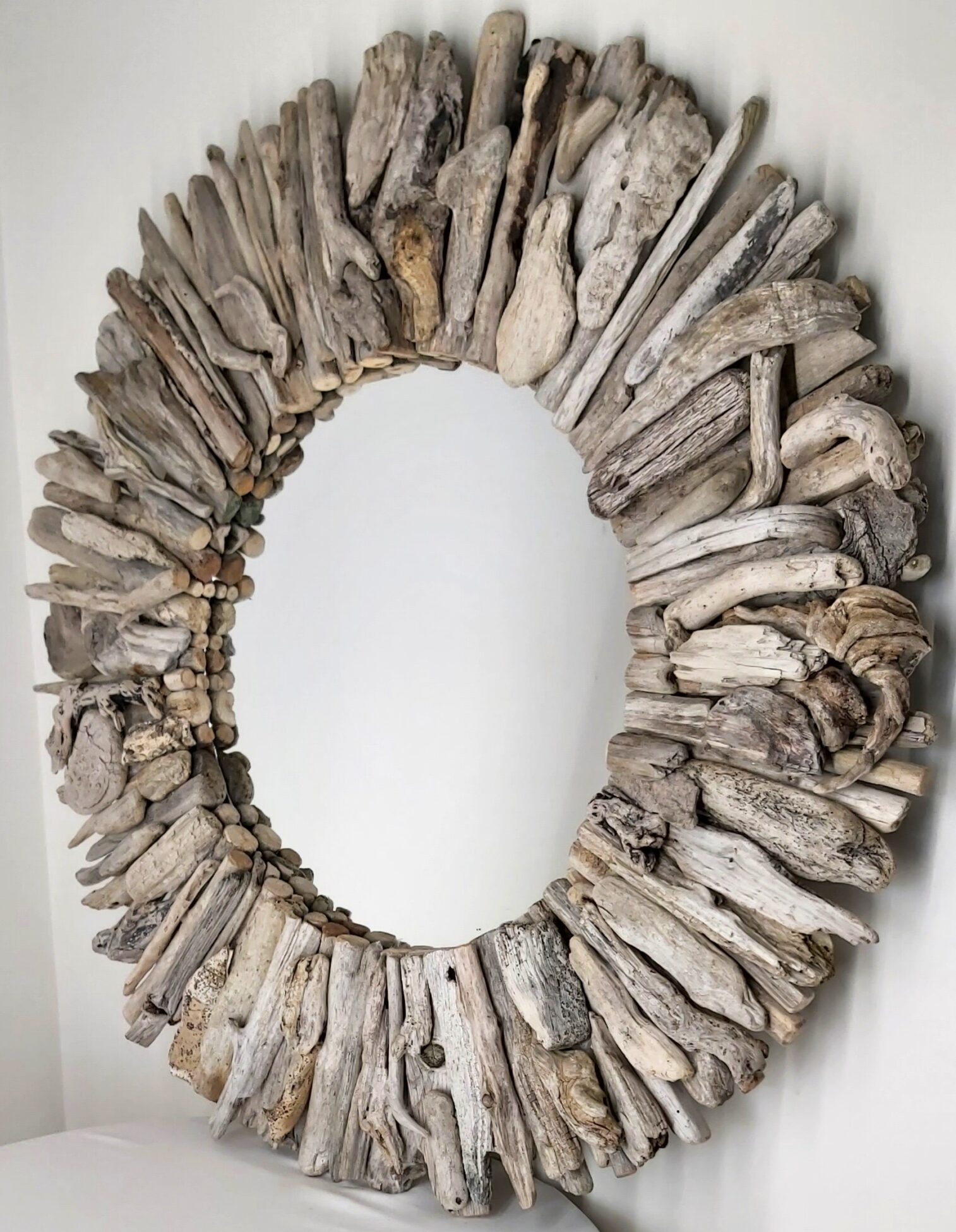 This driftwood mirror titled Sea Sculpture uses a mixture of light grey wood.
