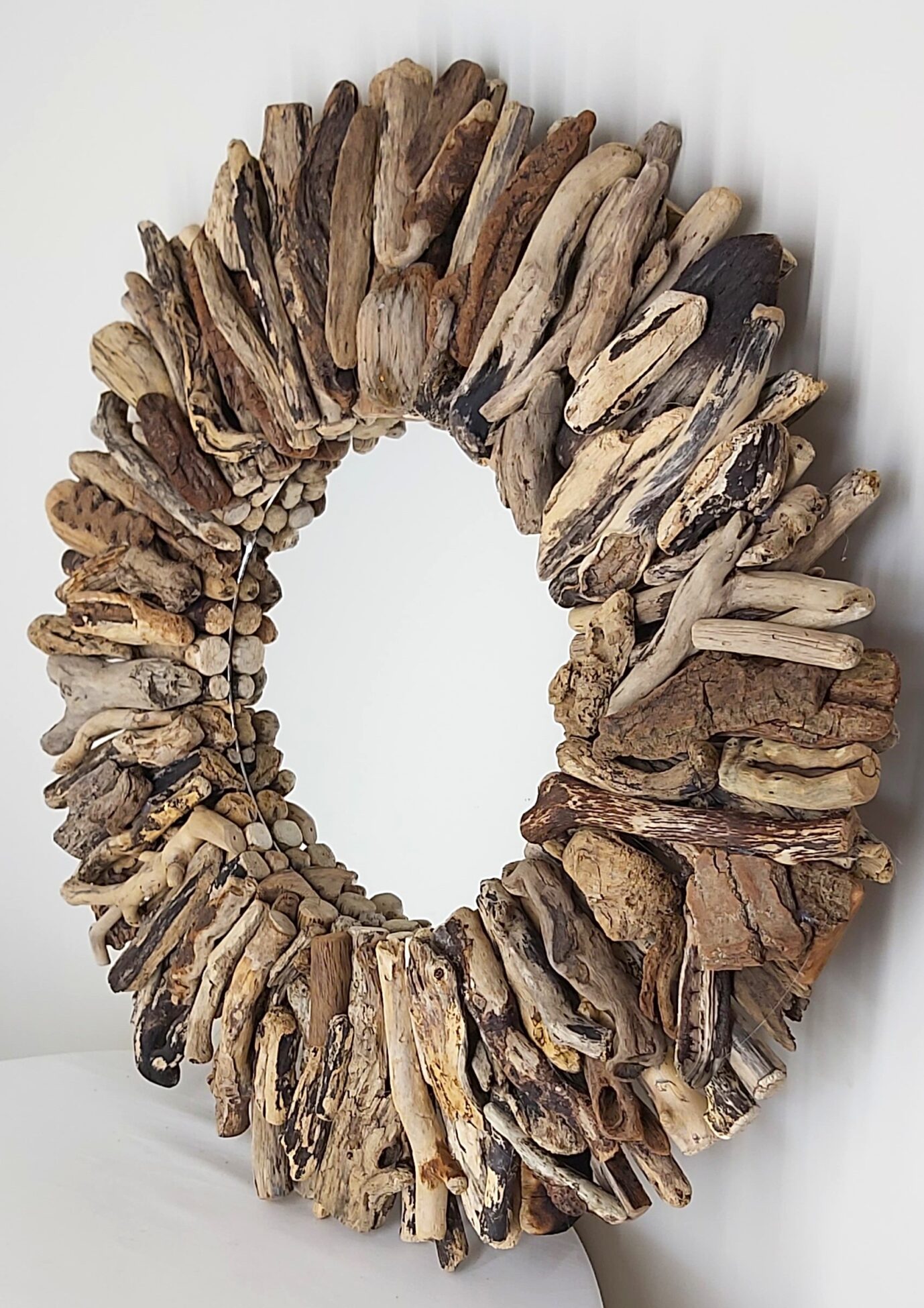This driftwood mirror titled Tide Treasure uses a mixture of coloured woods