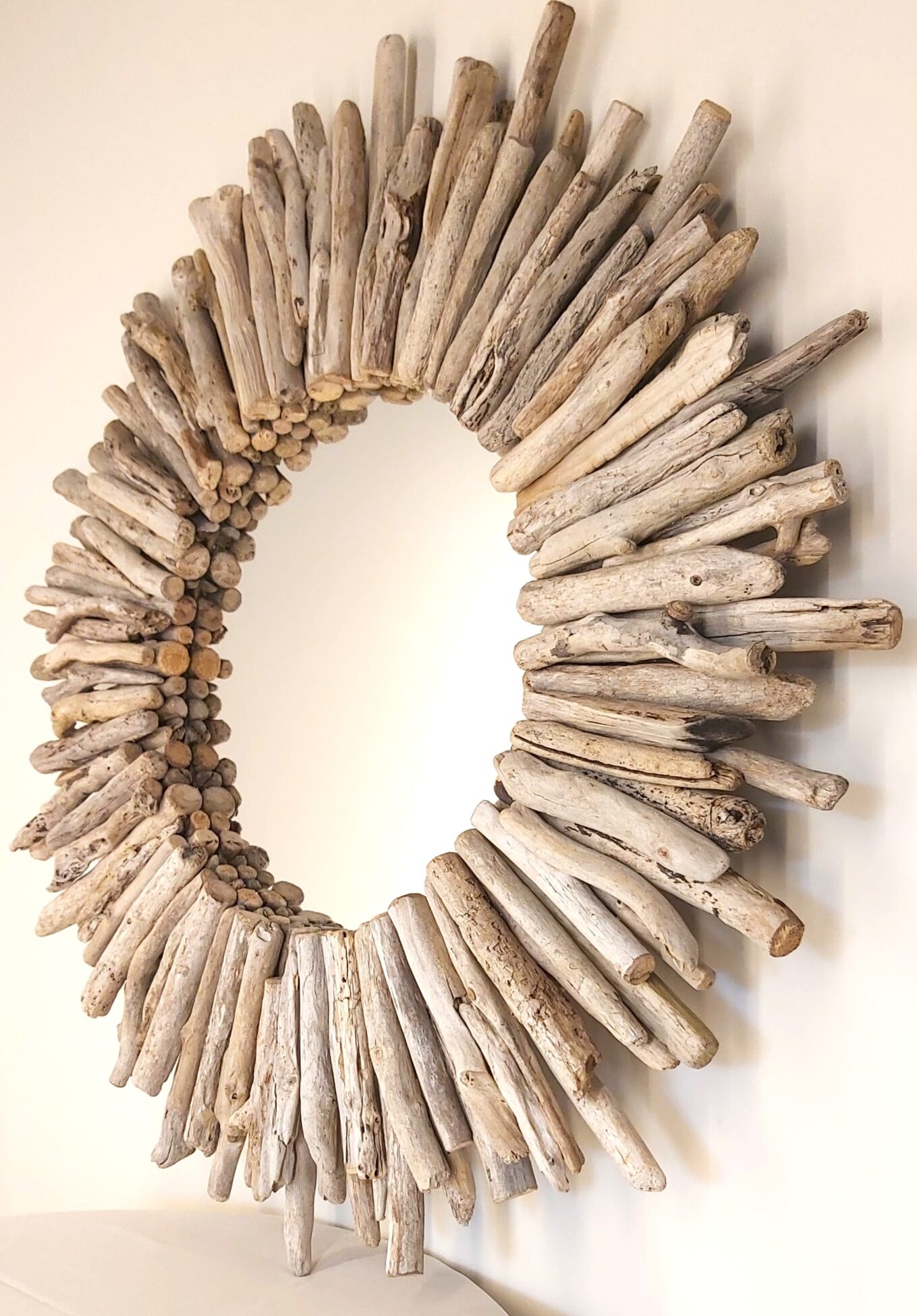 This driftwood mirror titled Sea Whisper uses a light grey woods